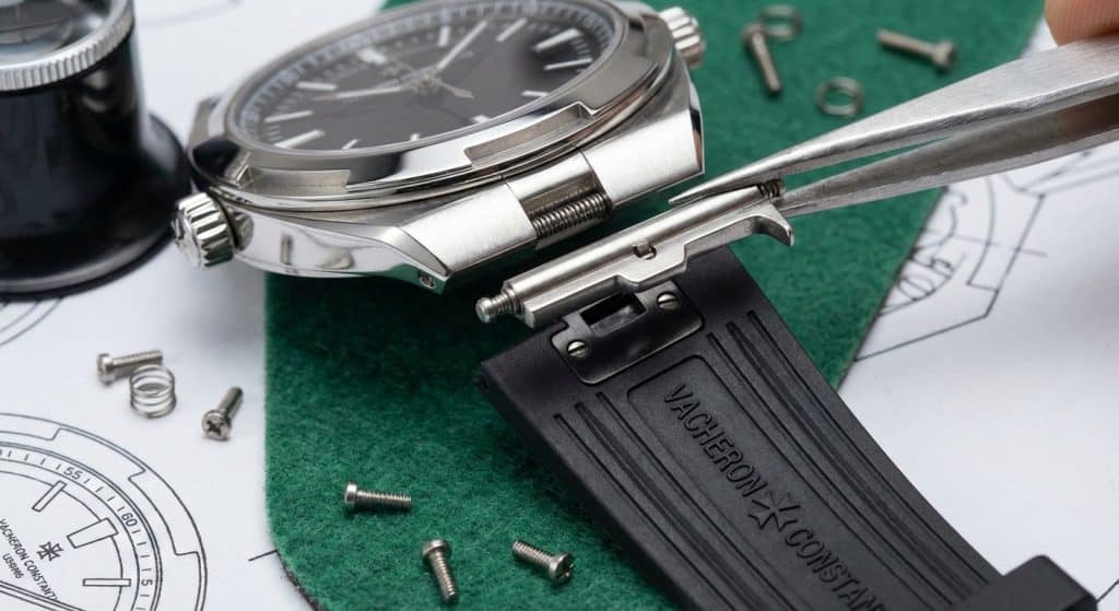 A detailed technical study of the quick-release lug mechanism on a ZF Factory Overseas 4500V, showcasing the spring-loaded locking bar and its compatibility with a genuine Vacheron Constantin rubber strap.