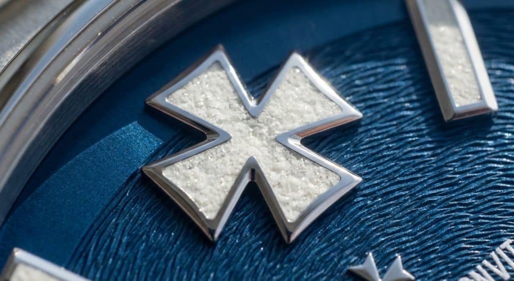 An extreme macro view captures the crystalline structure of Swiss Super-LumiNova BGW9 on the Maltese Cross indices of a 2026 ZF V3 Vacheron Constantin Overseas.