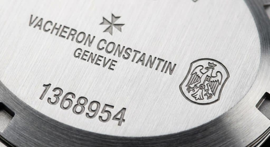 A macro 50x magnification photograph reveals the crisp, cold-laser engraved serial numbers and the Hallmark of Geneva on the brushed steel case back of a 2026 ZF Factory VC Overseas.