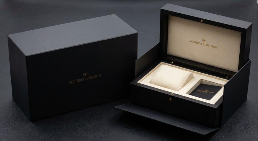 A high-resolution wide-angle shot displays the architectural layout of the 2026 Vacheron Constantin presentation set, emphasizing the matte finish of the outer sleeve and the structural rigidity of the primary housing.