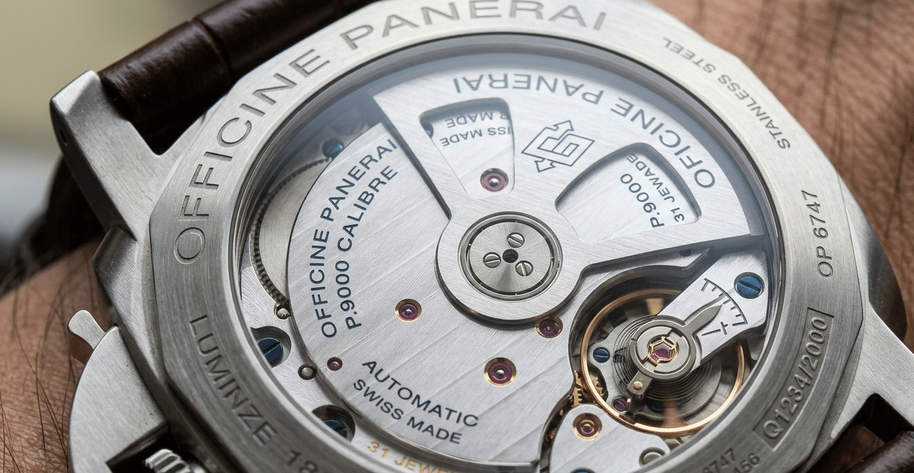 Close-up of a Panerai P.9000 movement through a display caseback, highlighting the balance bridge and Geneva stripes.
