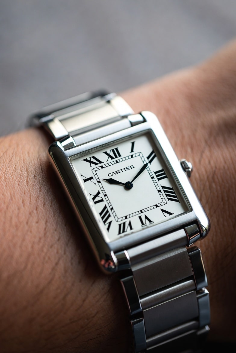 Cartier Tank Must on a wrist, showing elegant case profile and light reflections