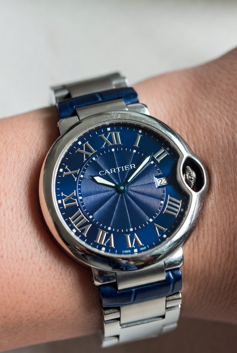 A Cartier Ballon Bleu super clone on a wrist, showing visible micro-scratches on its polished case after daily use.