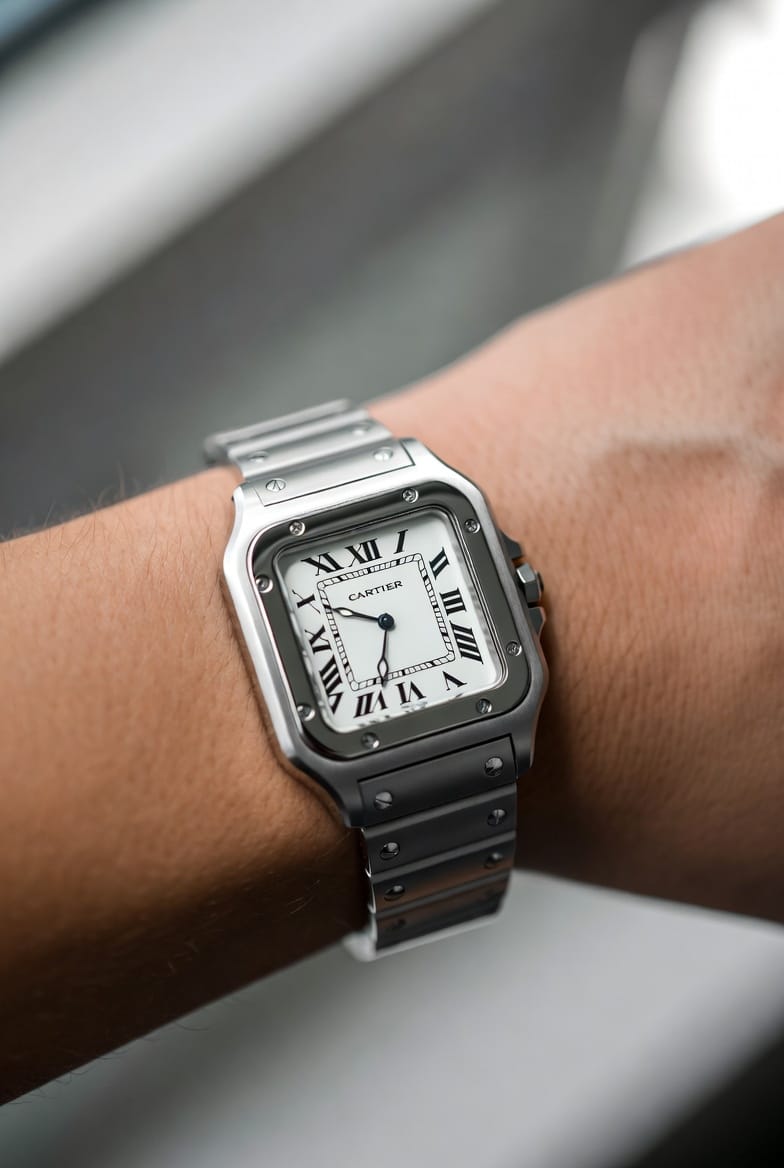 A Cartier Santos de Cartier on a wrist, showcasing its square case and integrated bracelet.