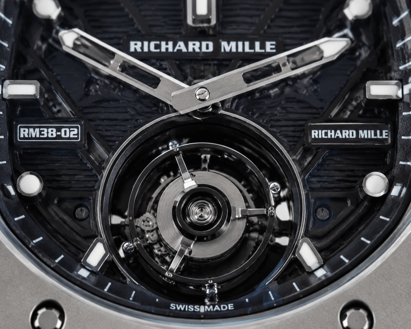 macro photo of a Richard Mille replica dial with a display tourbillon mechanism, showing a solid rotating ring with no visible balance wheel or escapement inside the cage opening