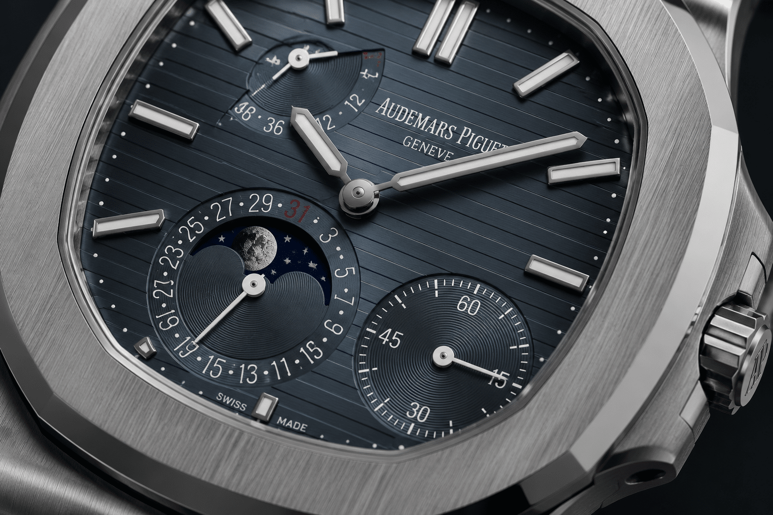 close-up replica Nautilus 5712 dial showing moonphase window, power reserve indicator, date subdial, and small seconds alignment points